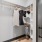 Model walk-in closet at our apartments for rent in Raleigh, NC, featuring clothes on hangers and shelves for storage.
