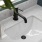 Detail of a model bathroom at our apartments for rent in Raleigh, NC, featuring white countertops and matte black faucet.